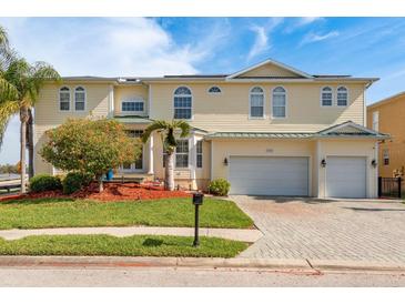 Two-story home featuring a three-car garage, beautiful landscaping, and classic architectural detailing at 339 Manatee Ln, Tarpon Springs, FL 34689
