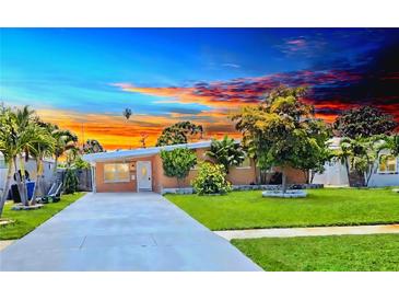 Charming single-story home with a well-manicured lawn and a long concrete driveway leading to the front door at 4018 Indianapolis Ne St, St Petersburg, FL 33703
