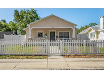 Charming single-story home with a welcoming front porch and a white picket fence at 1050 22Nd N Ave, St Petersburg, FL 33704