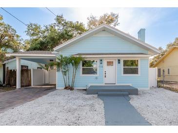 Charming light blue home featuring a quaint front yard and a convenient covered carport at 110 Kenwood Ave, Clearwater, FL 33755