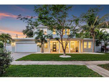 Beautiful two-story home featuring a well-manicured lawn, covered porch, and inviting curb appeal at dusk at 3711 W Barcelona St, Tampa, FL 33629