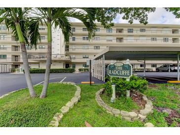 Exterior shot of The Radcliffe building with lush landscaping and covered parking at 8198 Terrace Garden N Dr # 109, St Petersburg, FL 33709
