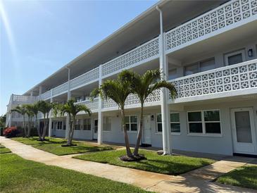 Two story condo complex features balconies with concrete decorative railing and small palm trees at 1001 77Th N Ave # 206, St Petersburg, FL 33702