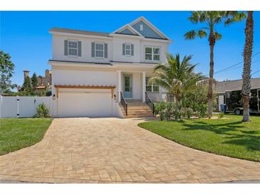 Charming two-story home featuring a brick driveway, manicured lawn and a two-car garage at 1739 1/2 Bayou Grande Ne Blvd, St Petersburg, FL 33703