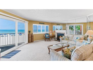 Bright living room with fireplace and beach views from the adjacent balcony and windows at 18400 Gulf Blvd # 1109, Indian Shores, FL 33785