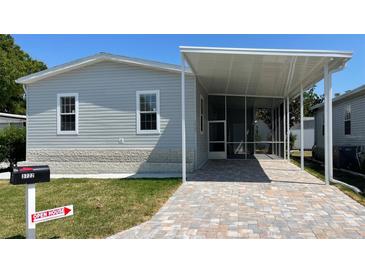Charming home exterior features a screened-in porch, paved driveway, and well-maintained lawn at 3722 Binnacle Dr, Tampa, FL 33611
