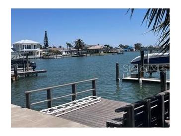 Waterfront property featuring a private dock with boat lift access on a sunny day at 510 64Th Ave, St Pete Beach, FL 33706