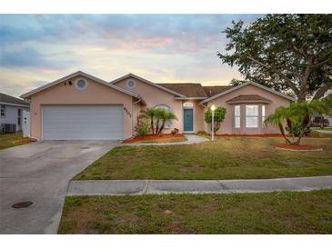 Charming single-story home featuring a manicured lawn, mature trees, and a two-car garage at 6507 61St E Dr, Palmetto, FL 34221