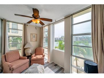 Cozy seating area featuring large windows with waterfront views and a ceiling fan at 7400 Sun Island S Dr # 206, South Pasadena, FL 33707