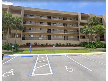 Condo building featuring multiple stories, balconies, palm trees and accessible parking at 90 S Highland Ave # 1217, Tarpon Springs, FL 34689