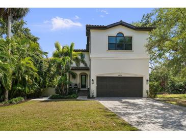 Stunning two-story home with a paver driveway and lush landscaping provides fantastic curb appeal at 4804 W Beachway Dr, Tampa, FL 33609