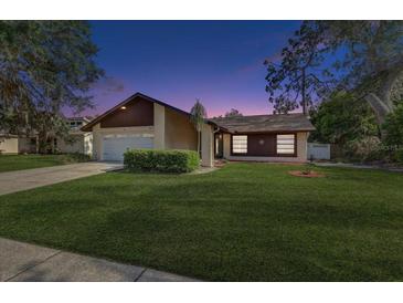Charming single-Gathering home with a well-maintained front yard, mature trees, and neutral color palette at 614 Sandalwood Dr, Plant City, FL 33563