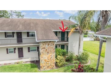Multi-story condo building featuring stone accents, balconies, and lush landscaping at 9851 113Th St # 206, Seminole, FL 33772