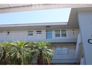 Condominium building featuring white railings, light gray exterior and palm trees on the grounds at 9950 47Th N Ave # 311, St Petersburg, FL 33708