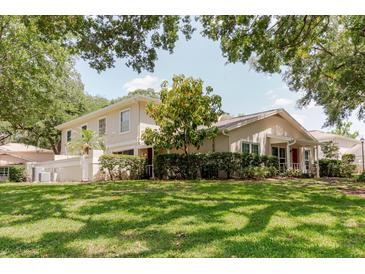 Charming two-story home with well-maintained landscaping and lush green lawn at 11802 Foxrun Ln, Temple Terrace, FL 33617
