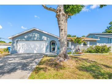 Charming single Gathering home with a two-car garage and mature tree in front yard at 14884 Cromwell Dr, Clearwater, FL 33764