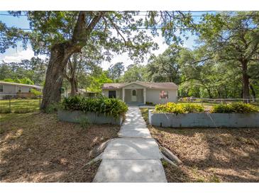Charming single story home with landscaped front yard, inviting entryway and mature shady trees at 7211 & 0 Sunnyside Dr, Brooksville, FL 34601