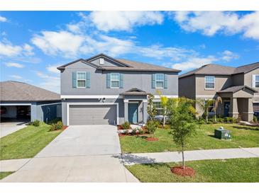 Two-story home with a well-manicured lawn, tidy flower beds, and a two-car garage at 11079 Linden Depot Rd, San Antonio, FL 33576