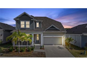 Charming two-story home featuring a covered front porch, well-maintained lawn, and an attached two-car garage at 1432 Gopher Loop, Tarpon Springs, FL 34689