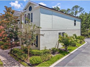 Charming two-story home featuring unique architectural detail, beautiful landscaping, and a well-maintained yard at 311 Vista Cruiser Ln, Oldsmar, FL 34677