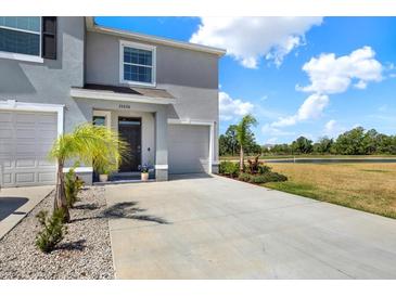 Inviting two-story home featuring a well-manicured lawn and a spacious driveway at 33030 Major Oak Dr, Wesley Chapel, FL 33545