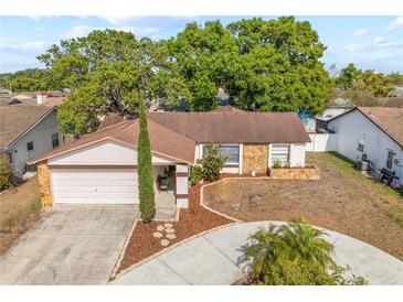 Charming single-story home with a stone accent, well-kept lawn, and a circular driveway at 11318 Stoneybrook Path, Port Richey, FL 34668