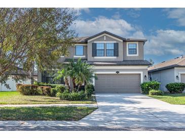 Charming two-story home featuring a spacious garage and beautifully landscaped front yard at 11525 Scarlet Ibis Pl, Riverview, FL 33569