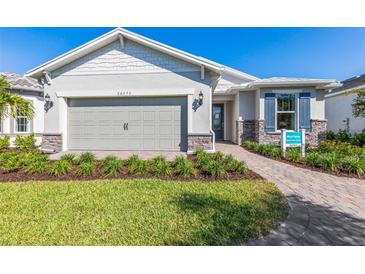 Charming one-story home featuring a two-car garage and beautifully landscaped front yard on a sunny day at 17206 Luminous Ave, Venice, FL 34293