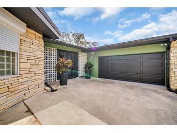 A spacious driveway leads to an attached garage, complemented by decorative plants, enhancing the home's curb appeal at 307 Orangewood Ln, Largo, FL 33770