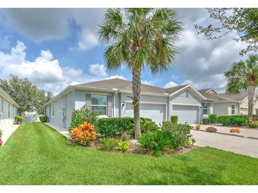 Charming single-story home features a lush, landscaped front yard with vibrant plants and a well-manicured lawn at 32829 Woodthrush Way, Wesley Chapel, FL 33545