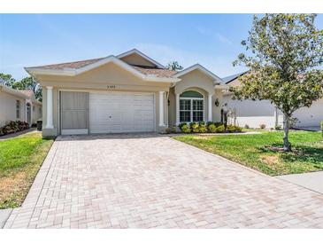 Charming single-story home featuring a brick driveway and meticulously maintained landscaping at 5429 Legend Hills Ln, Spring Hill, FL 34609