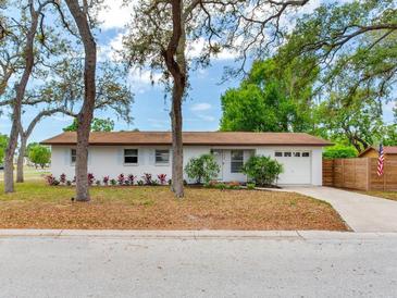 Charming single-story home featuring a well-manicured front yard, mature trees, and an attached one-car garage at 1700 25Th N St, St Petersburg, FL 33713