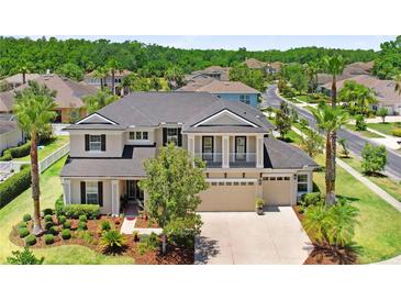 Beautiful two-story home featuring manicured landscaping, a three-car garage, and a welcoming front facade at 3243 Watermark Dr, Wesley Chapel, FL 33544