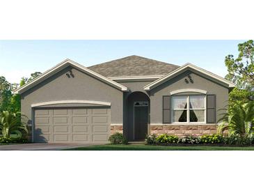 Charming one-story home with a two-car garage, stone accents, neutral paint, and manicured lawn at 32692 Osprey Peak Way, San Antonio, FL 33576