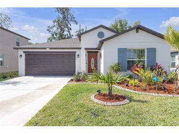 Charming single-story home with a well-manicured lawn and colorful landscaping at 36568 Garden Wall Way, Zephyrhills, FL 33541