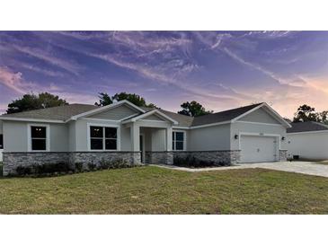 Charming single-story home with a two-car garage, stone accents, and well-maintained landscaping at 37533 Teri Ct, Dade City, FL 33525