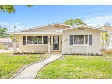 Charming single-story home features a well-manicured lawn, inviting walkway, and freshly painted exterior at 1323 48Th N Ave, St Petersburg, FL 33703