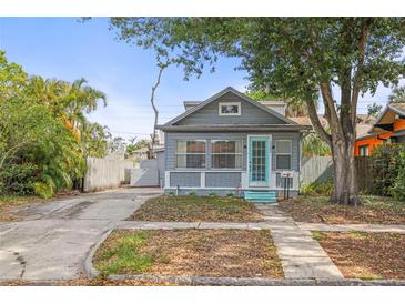 Charming bungalow-style home with blue door and mature landscaping, shaded by a mature tree and welcoming walkway at 2235 Burlington N Ave, St Petersburg, FL 33713