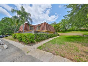 Charming townhome features a unique roof design and a well-maintained, landscaped yard at 2627 2Nd Ct, Palm Harbor, FL 34684