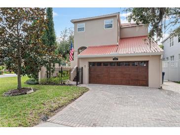 Inviting home with a red tile roof, a paver driveway, and a well-manicured lawn at 2701 W Bay Ave, Tampa, FL 33611
