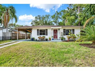 Charming single-story home with a well-manicured lawn, carport, and inviting front porch at 511 San Jose Dr, Dunedin, FL 34698