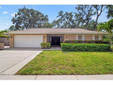 Charming single-story home with a lush green lawn, well-maintained landscaping, and a two-car garage at 5600 Bay Pines Lakes Blvd, St Petersburg, FL 33708