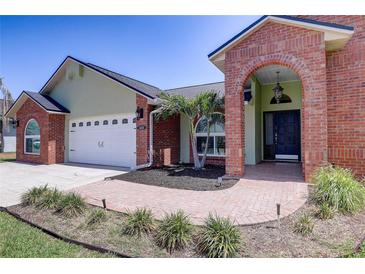 Charming single-story home featuring a brick archway, mature landscaping, and an attached two-car garage at 1416 Buckner Rd, Valrico, FL 33596