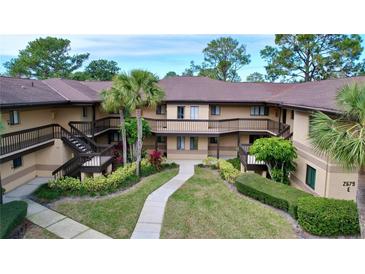 Exterior view of a two story condo community with walkways and lush landscaping at 2679 Sabal Springs Cir # 102, Clearwater, FL 33761