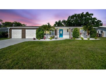 Charming single-story home featuring a well-manicured lawn, inviting blue door, and an attached two-car garage at 3922 Fontainebleau Dr, Tampa, FL 33634