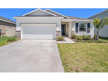 Charming single-story home with well-maintained lawn and a two-car garage at 5464 Flint Hills Dr, Wimauma, FL 33598