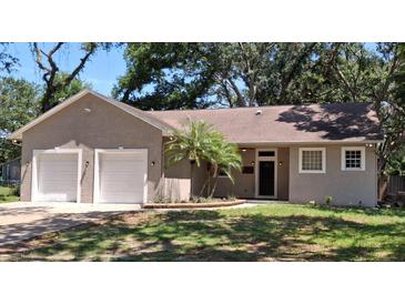 Charming single-story home featuring a two-car garage, landscaped yard, and a classic front entrance at 6994 Fort King Rd, Zephyrhills, FL 33541