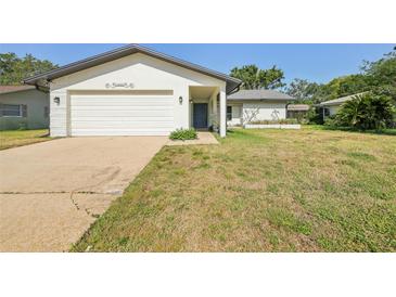 Charming single-story home featuring a well-manicured lawn and an attached two-car garage at 1605 W Dorchester Dr, Palm Harbor, FL 34684
