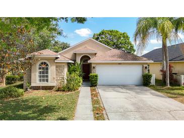 Charming single-story home with a well-manicured lawn, stone accents, and a two-car garage at 19227 Garden Quilt Cir, Lutz, FL 33558