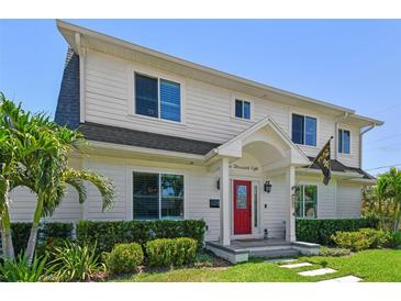Charming two-story home with a manicured lawn, a red front door, and lush landscaping at 3008 S Church Ave, Tampa, FL 33629